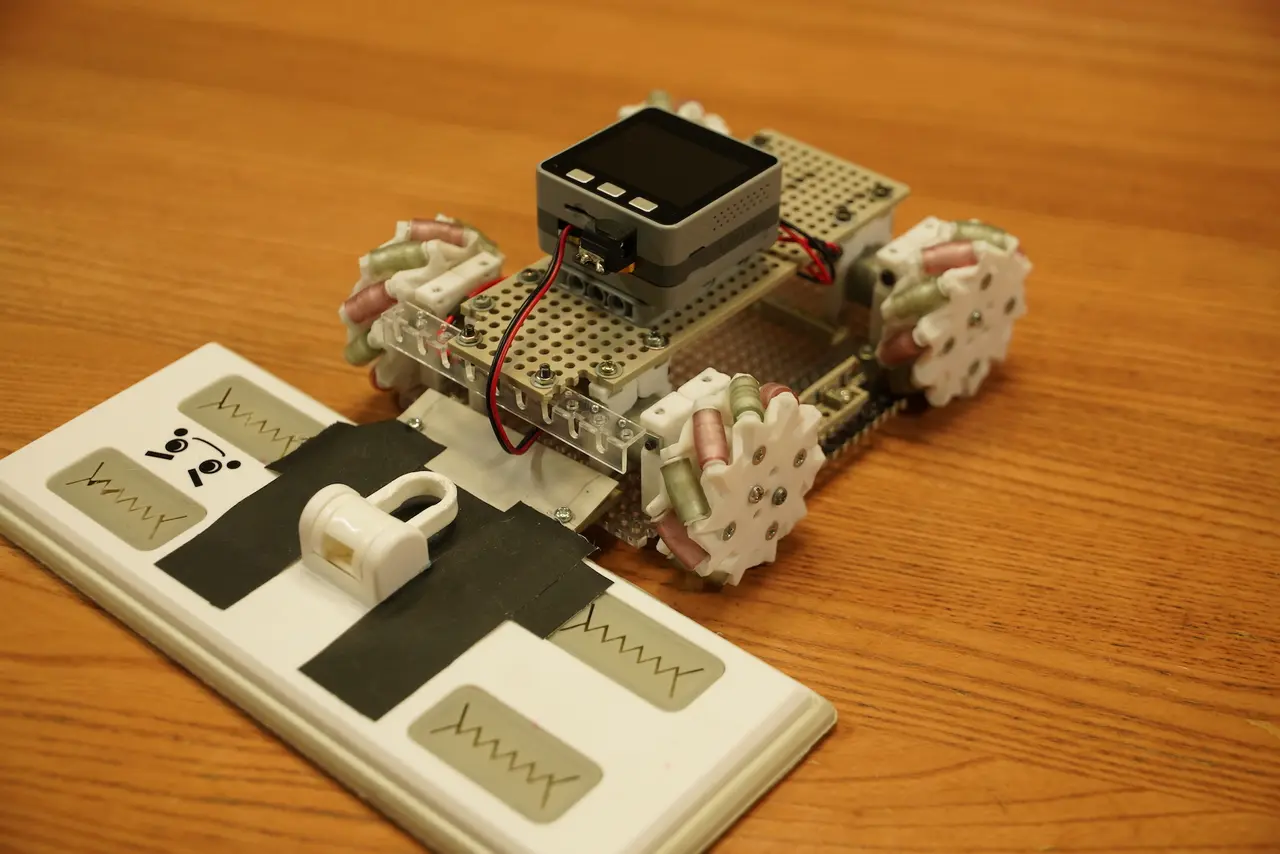 傾けて操作するコントローラーと、雑巾を取り付けた拭き掃除ロボット