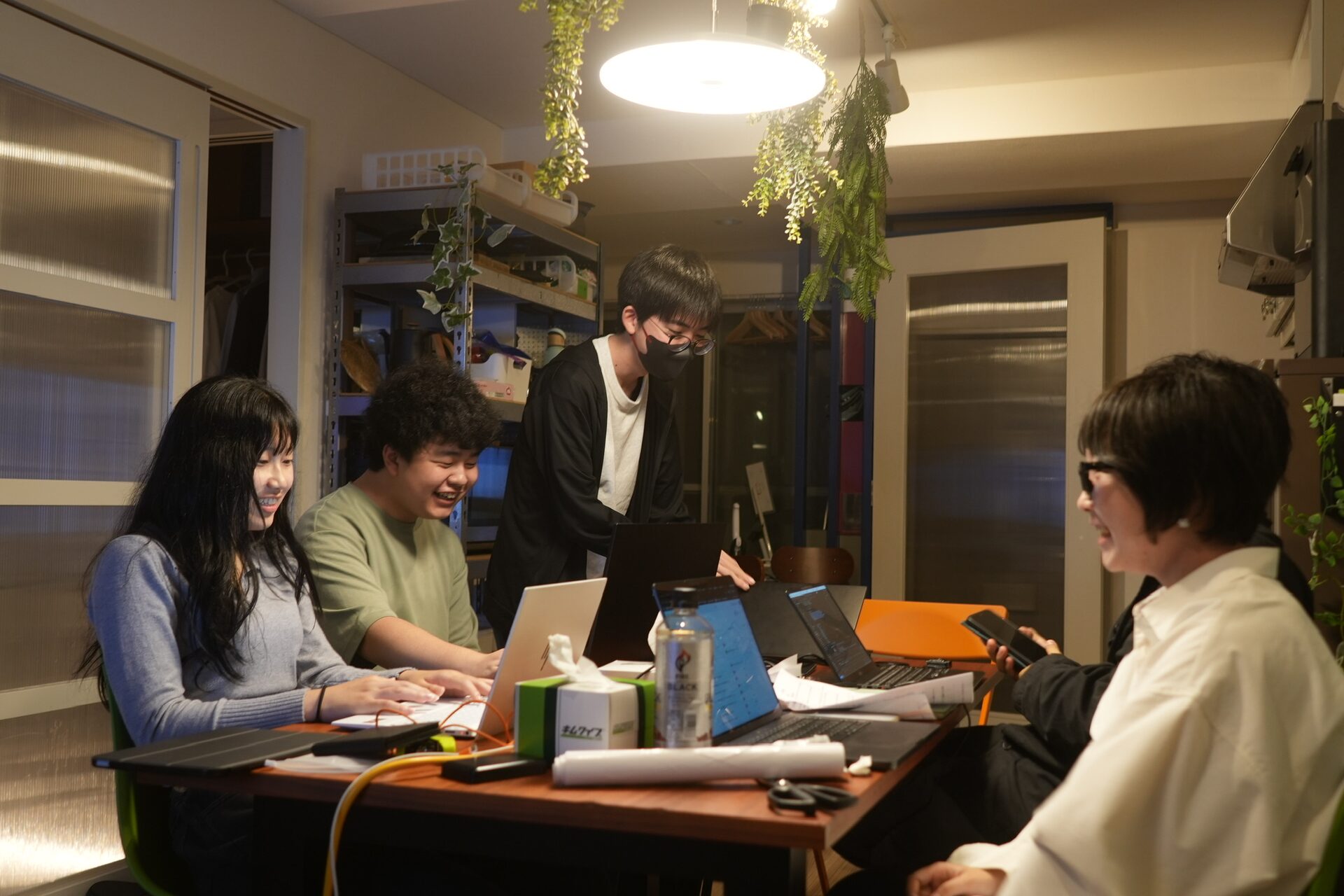 kusuwataのメンバーがテーブルを囲んで相談している様子