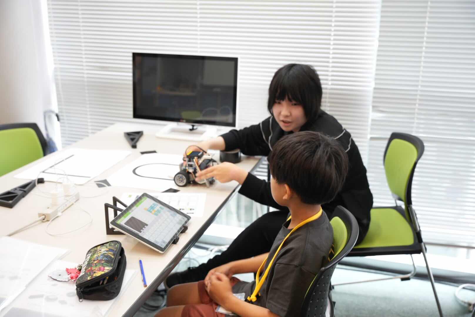 ロボットを前にして子どもへ説明しているロボットラボの様子